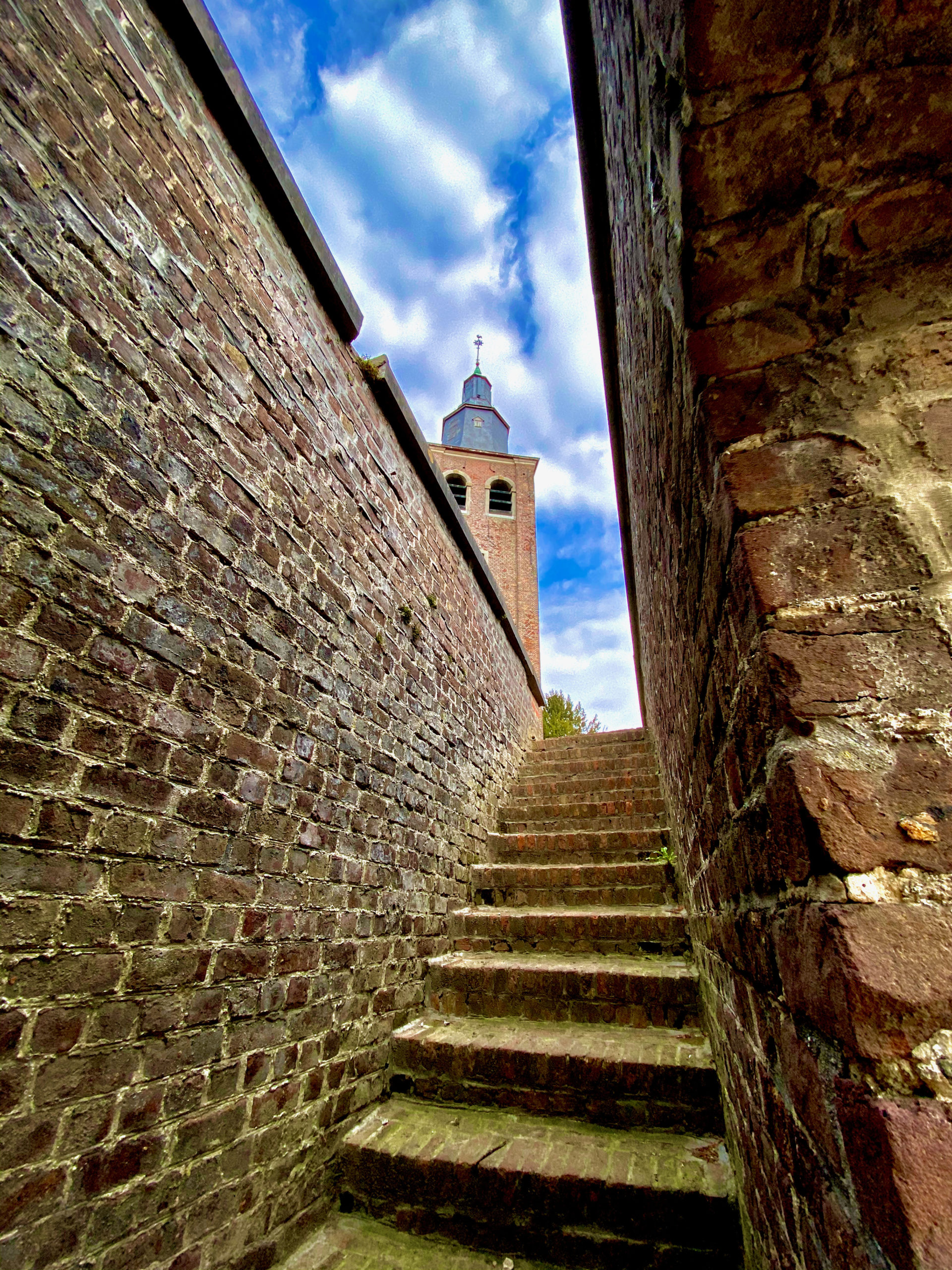 Sint-Machutuskerk in Wannegem-Lede met een hoger gelegen ommuurd kerkhof met trap